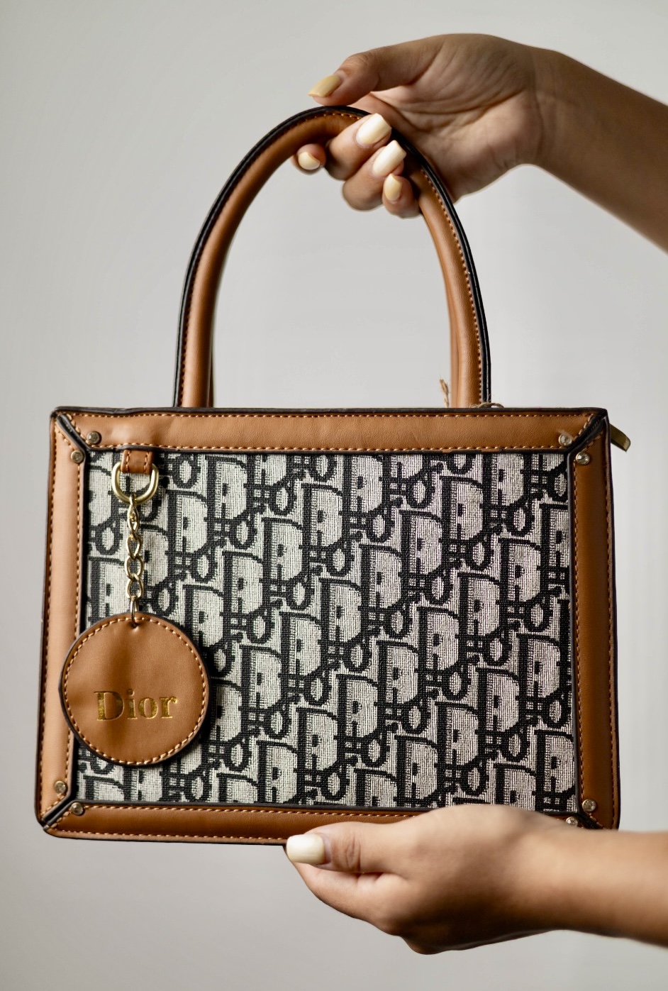 58931cae-cfbc-41de-93ac-863041bf362f BOLSA DIOR LETRAS NEGRAS CON ORILLA CAFE