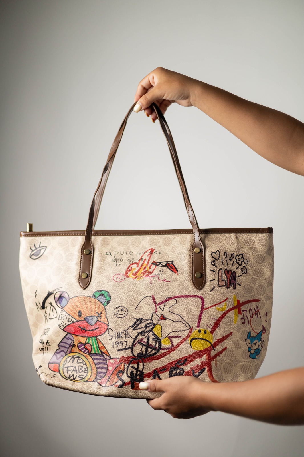 f1314e26-6ff9-47cc-b68c-fa4e09b78397 BOLSA GRANDE OSO DE COLORES CORREA CAFE