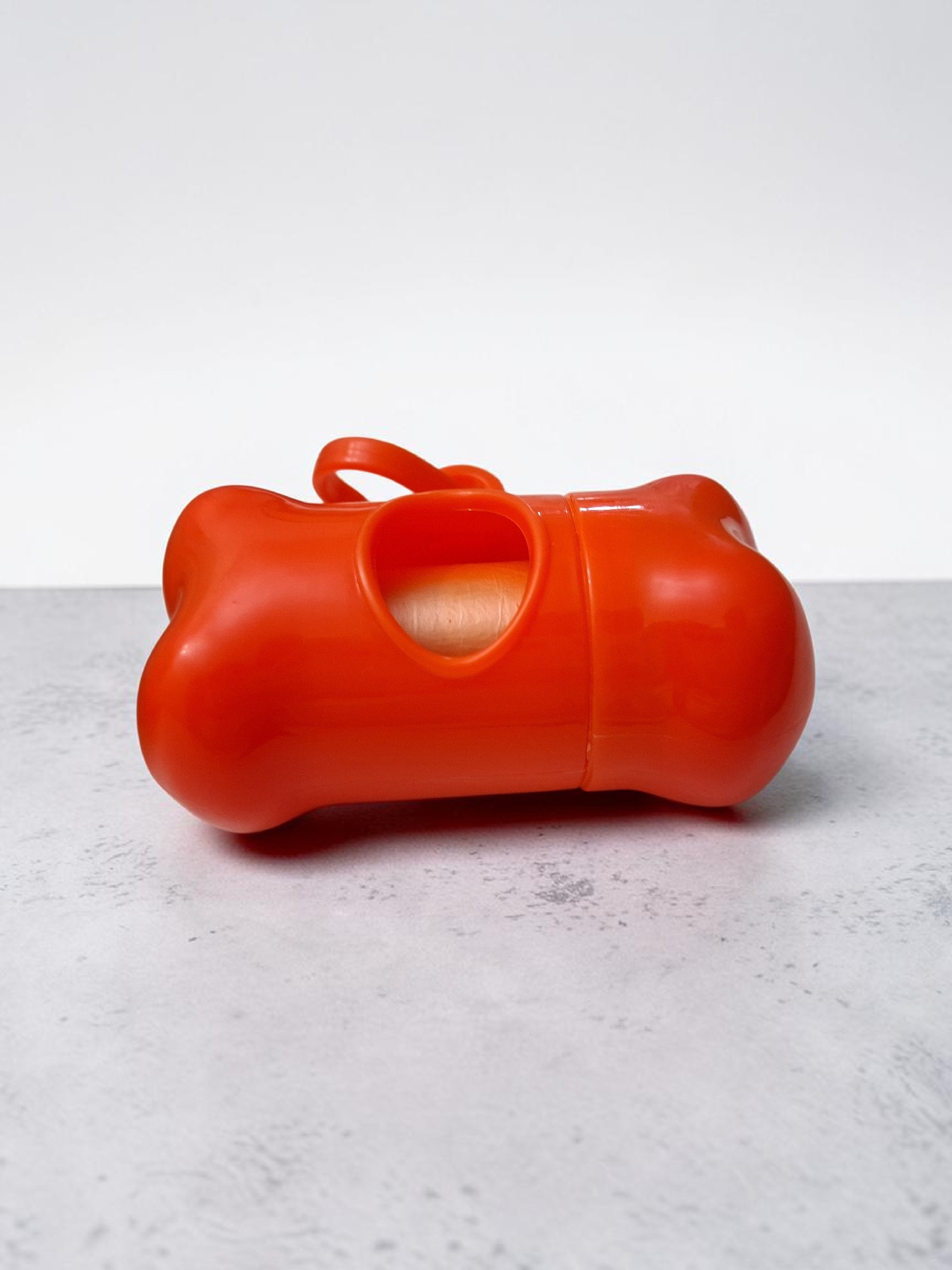 Dispensador de bolsas para la po en forma de hueso color naranja