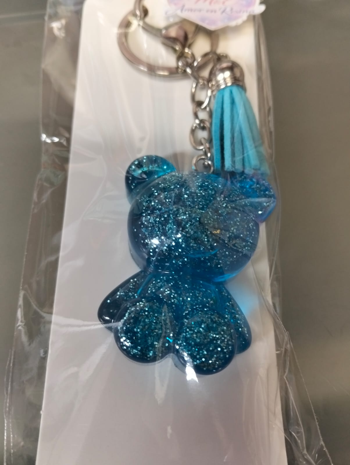 llavero de resina en forma de osito azul agua con destellos brillantes